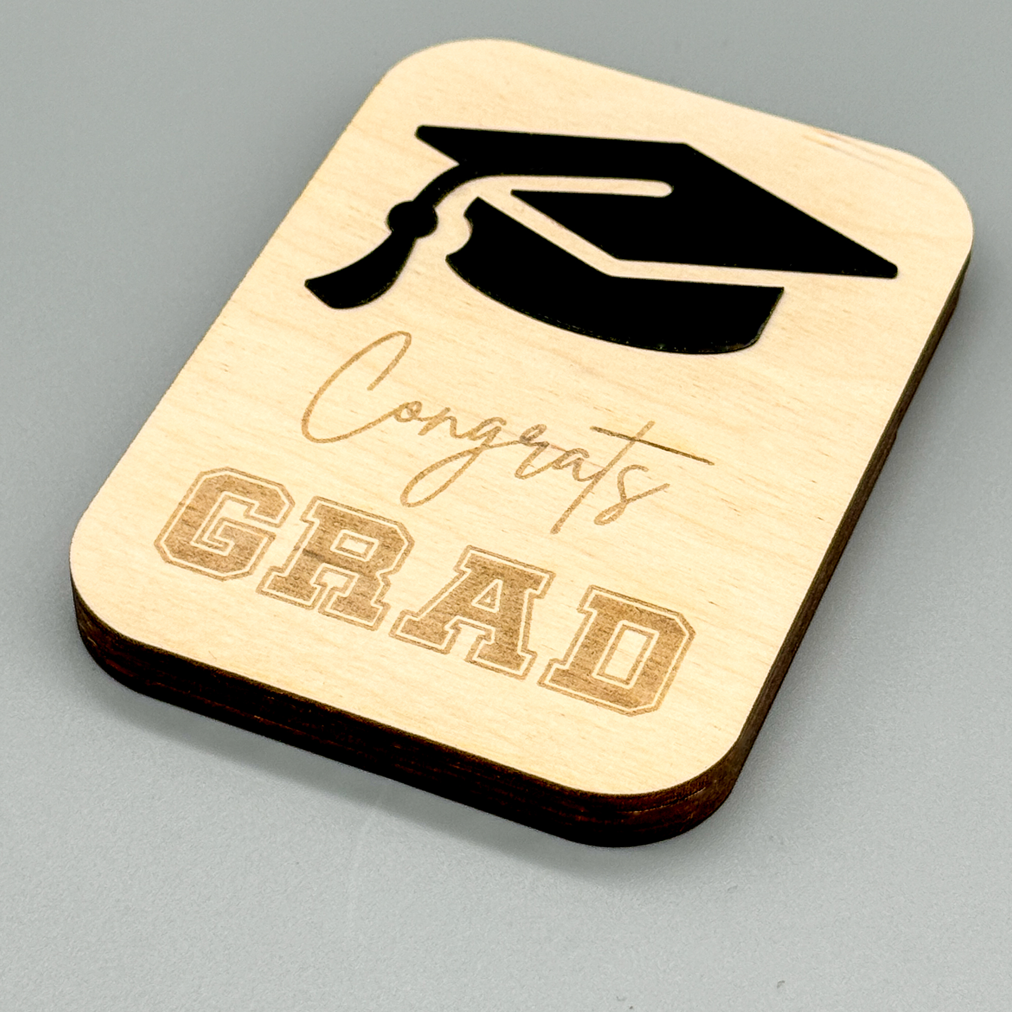 laser cut DIY gift card holder with black cap and "Congrats Grad" engraved on front