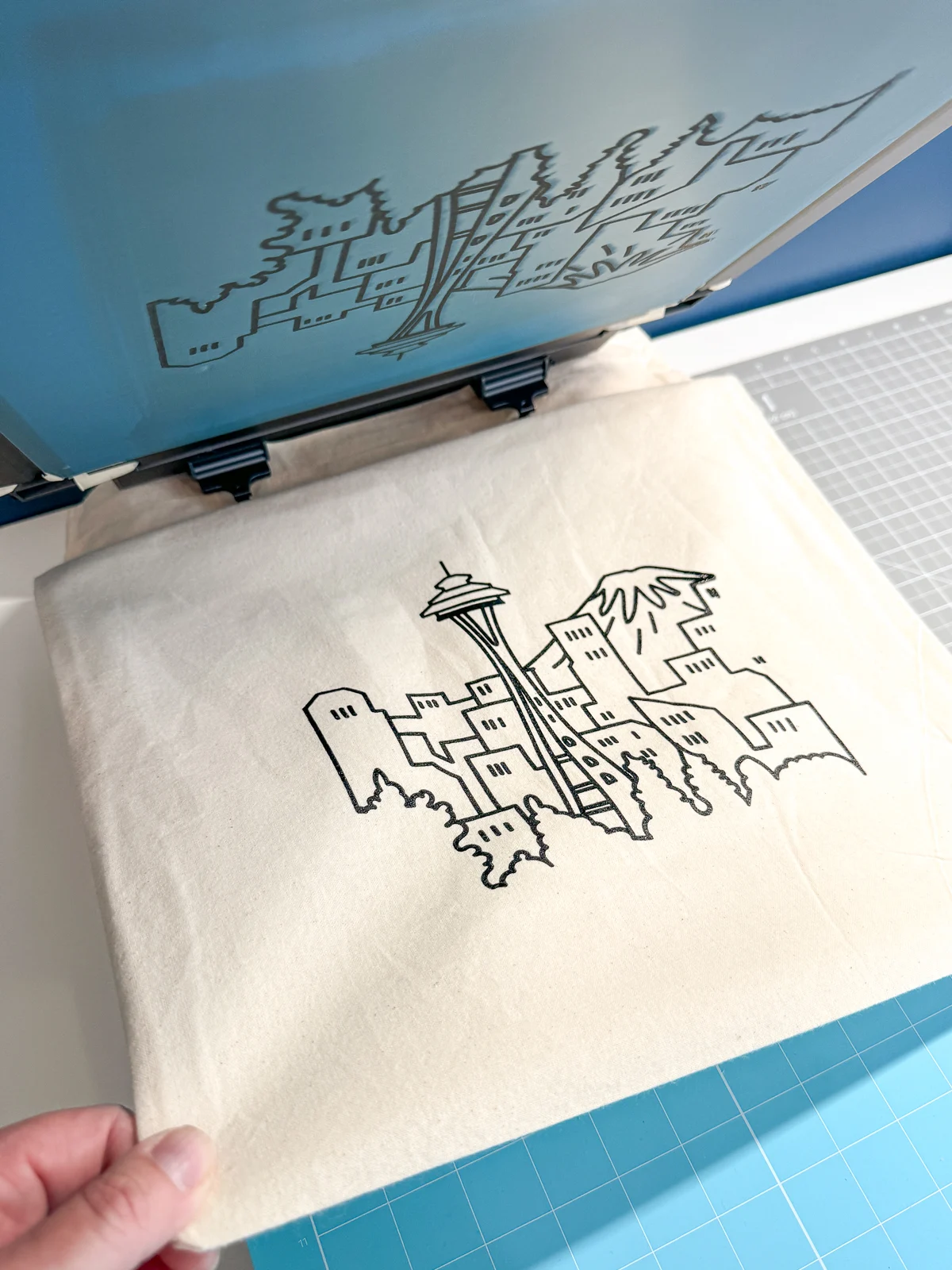 pulling the tote bag off the screen printer sticky mat