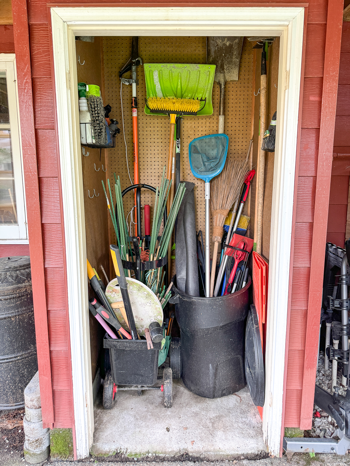 small garden shed with organized tools and doors removed