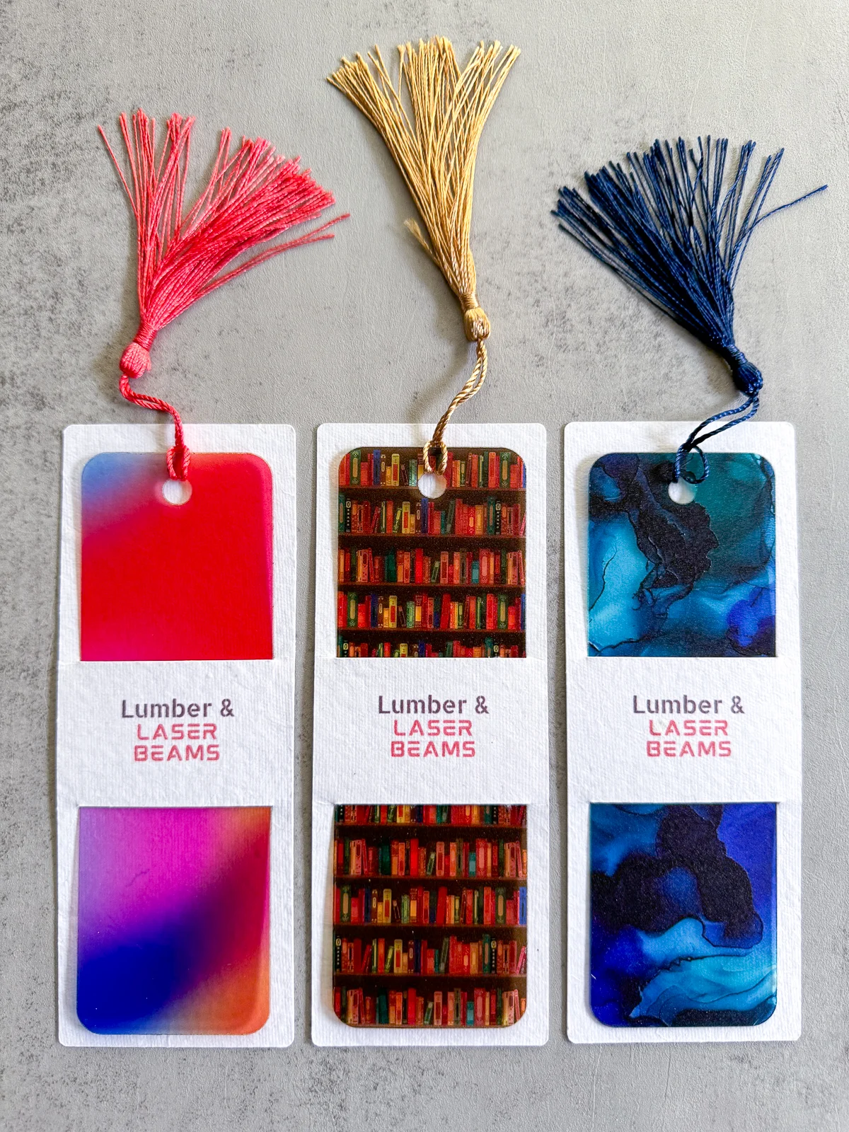 set of three DIY acrylic bookmarks with tassels and paper sleeves