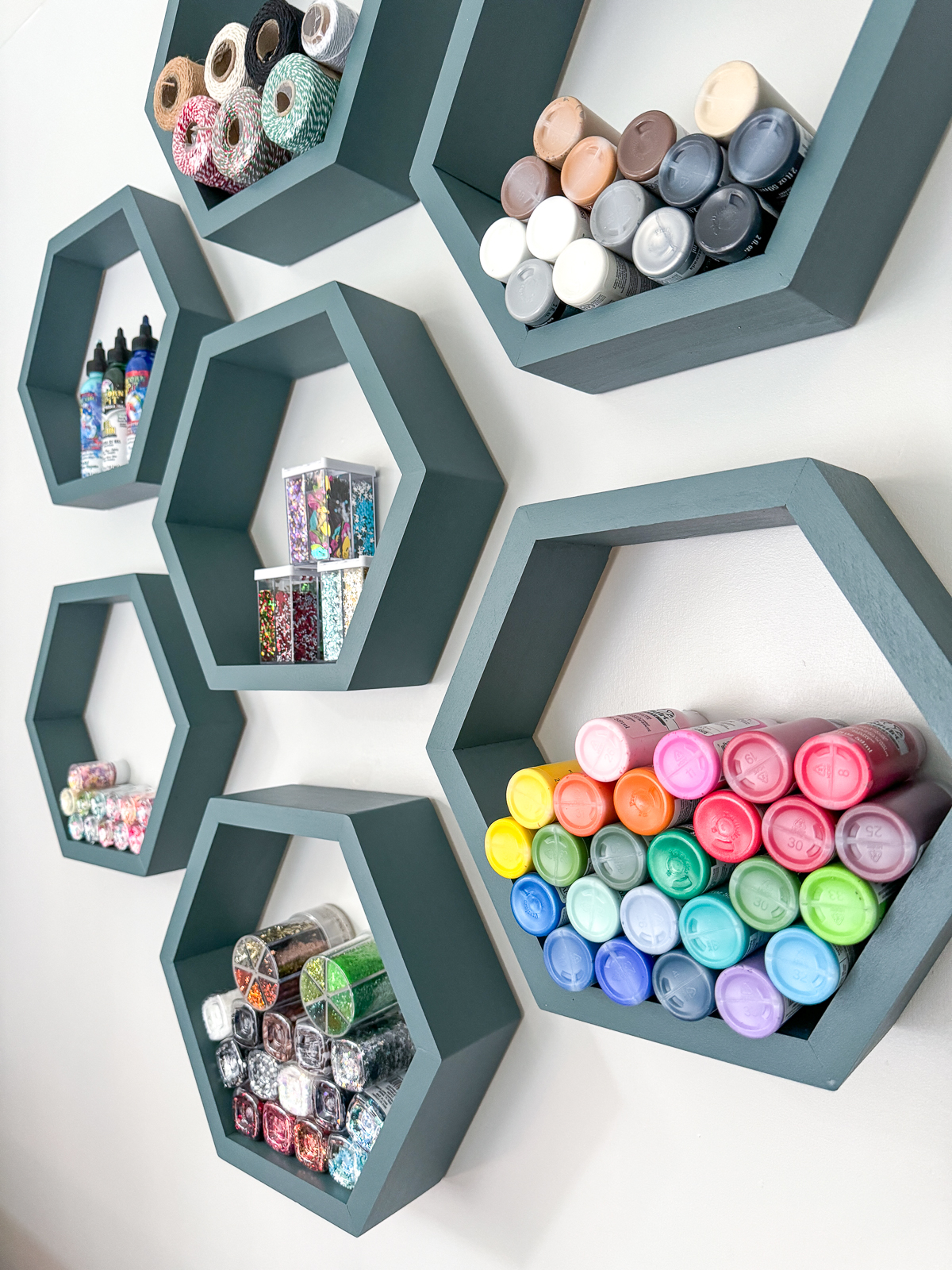 craft supplies displayed on hexagon wall shelves