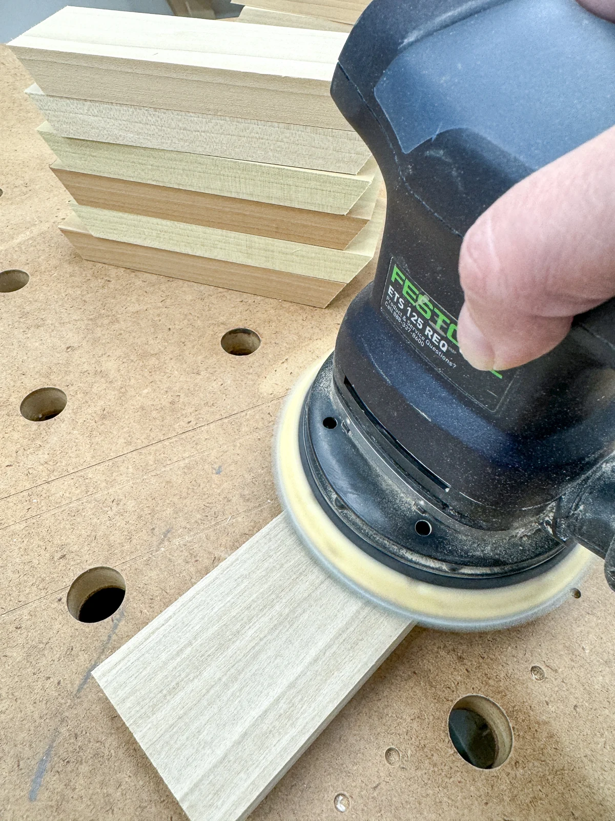 sanding the cut pieces for the hexagon shelves before assembly