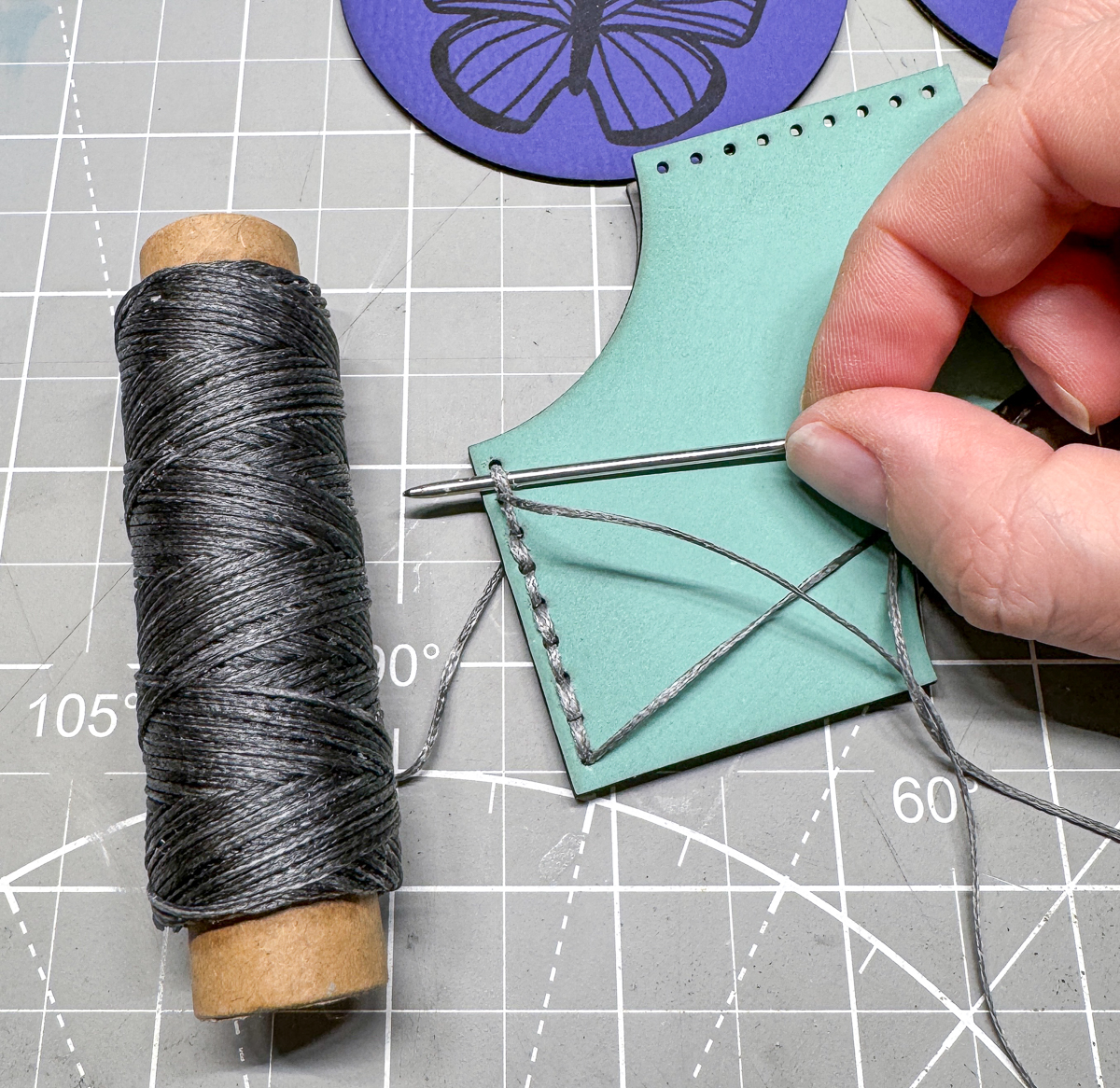 stitching together both sides of the leather corner bookmark