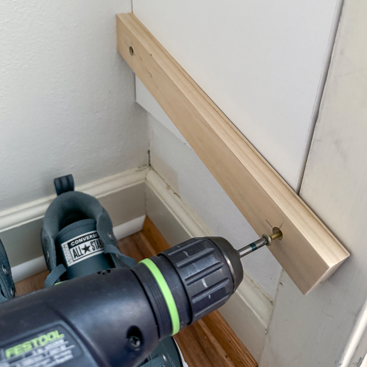 installing the first slanted shoe shelf bracket inside the closet