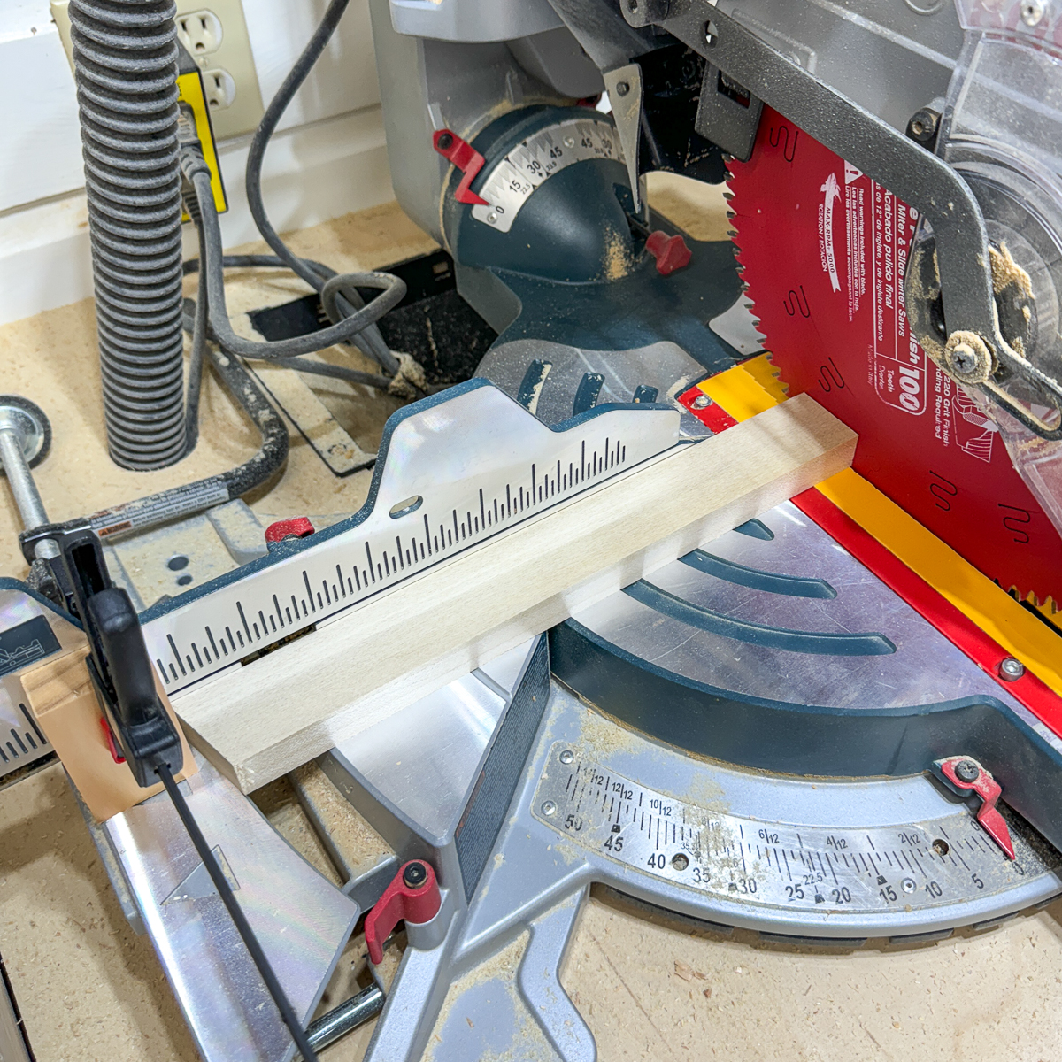 setting up a miter saw stop block to cut all the shelf support brackets to the same length with an angle on one end