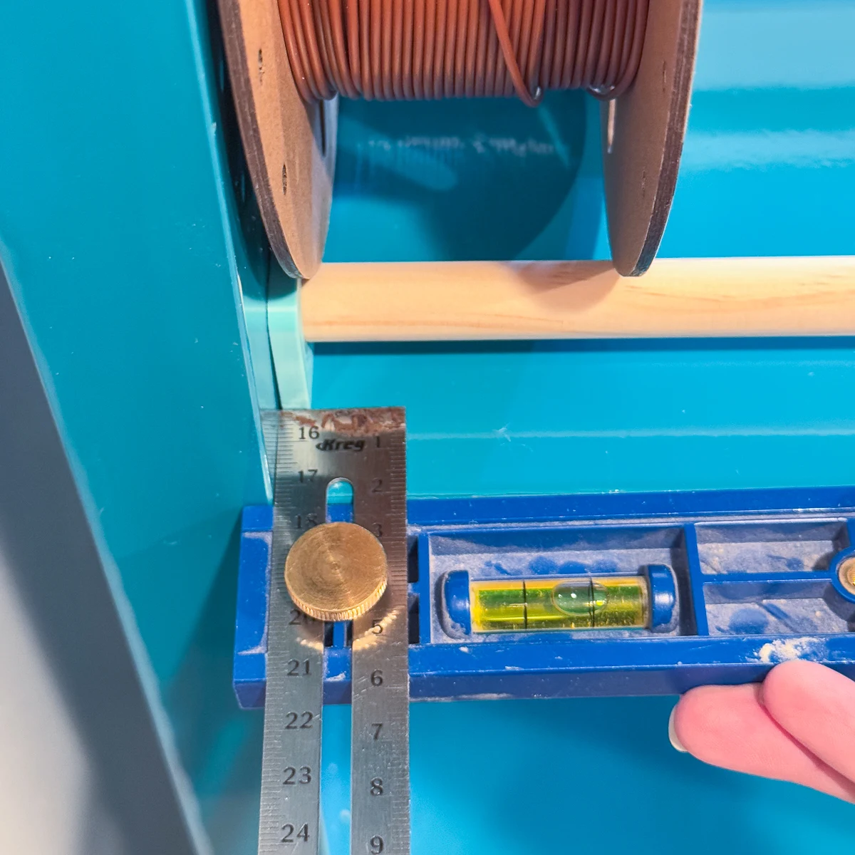 using the Kreg multi-mark tool to measure the distance from the front of the shelf to the bracket